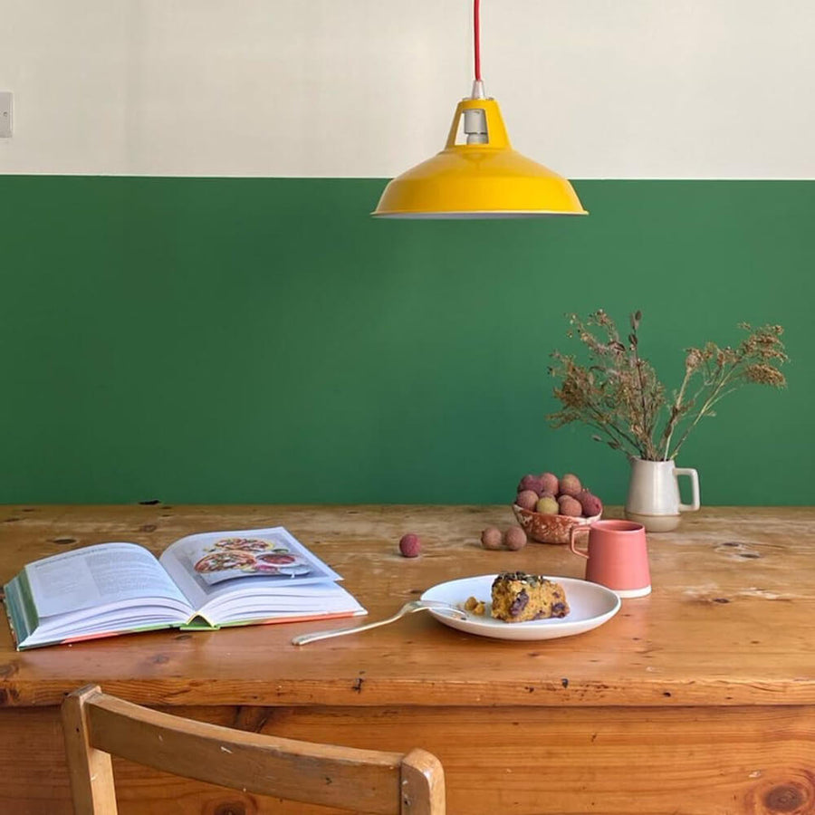 Dining room painted in Lick Green 07 with a yellow pendant lamp above the table