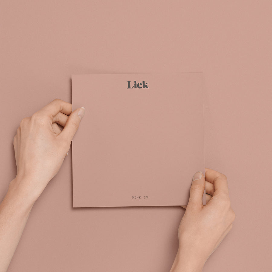 Hands holding a Peel & Stick sample of Pink 13